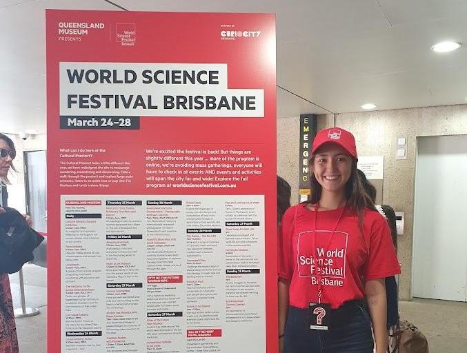 Cristina Sheehan standing next to a sign for World Science Festival Brisbane