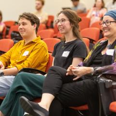 Three student sitting in the lecture theatre.