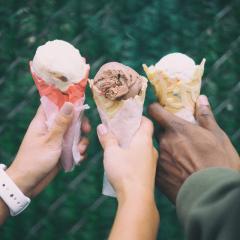Three hands holding an ice cream each