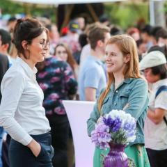 SSP event - two women standing in a crowd engaged in conversation