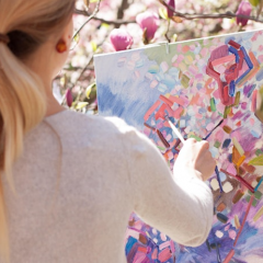 Woman painting on a canvas.