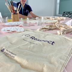 UQ Respect Tote bag with art supplies in the background