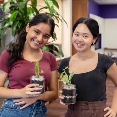 Two Dutton Park students holding their DIY terrariums.