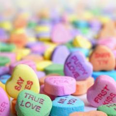 Colourful heart-shaped candy with romantic words printed in red on one side