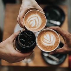 Three people giving cheers with coffee