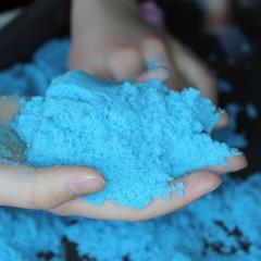 Person holding blue kinetic sand