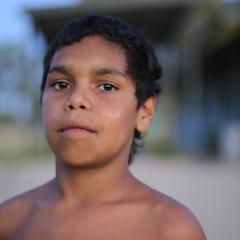 Screen capture of In My Blood It Runs with an Aboriginal boy looking straight to the camera.