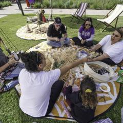 Women sitting in a circle enjoying a basket weaving workshop at Herston campus.