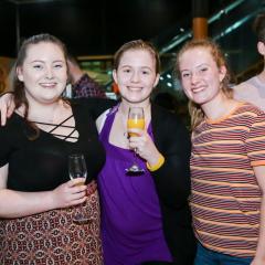 Group of students standing together for a photo with drinks in hand